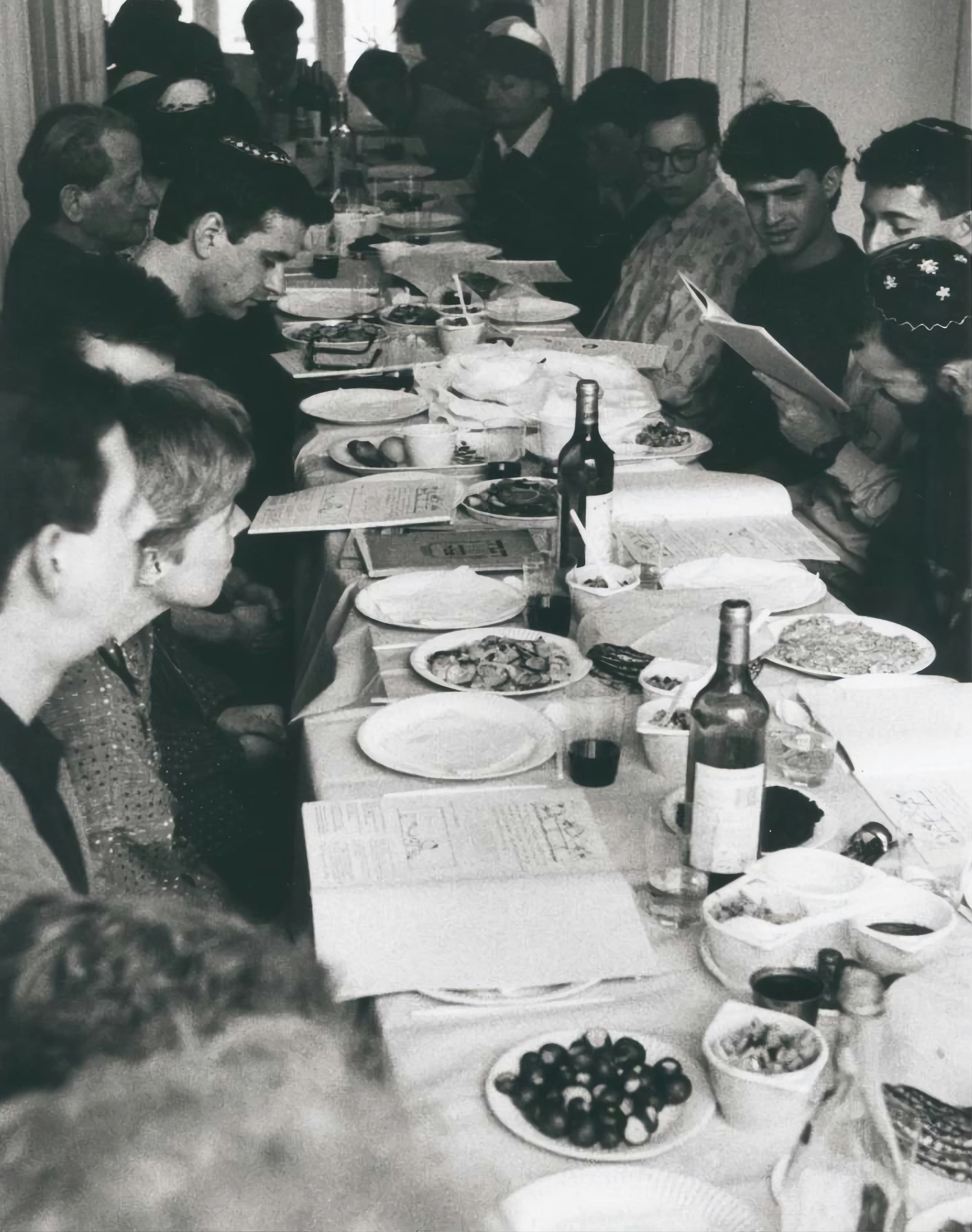 People seated around a long table sharing a meal